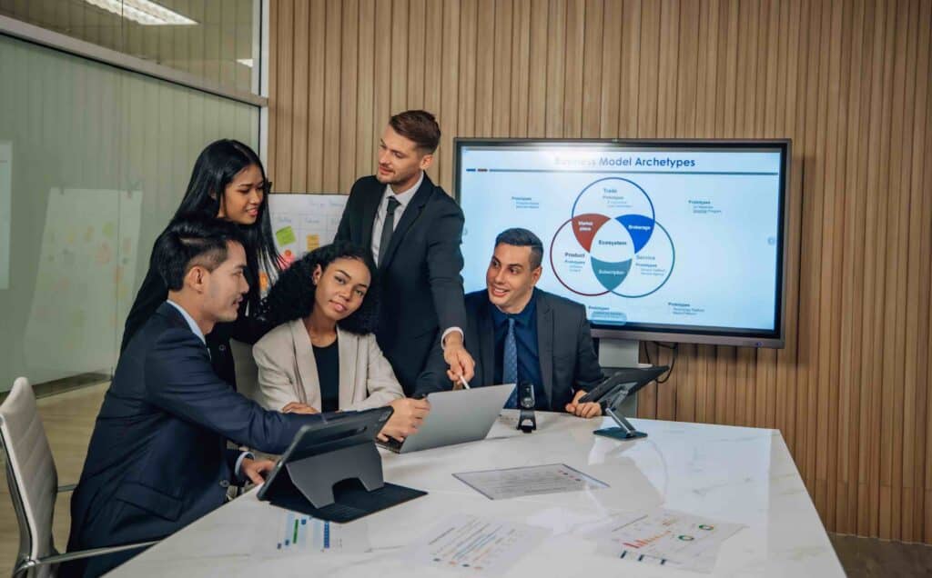 Diverse team innovates for sales KPIs via collaborative brainstorming to develop business models.